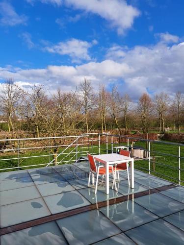 a white table and two chairs on a patio at Domein Den Buiten Bed And Breakfast DnD in Sint-Niklaas