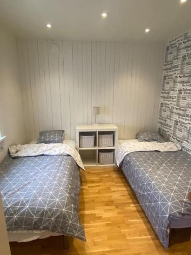 a bedroom with two beds and a wooden floor at Gästhus i Borås (Guest House) in Borås