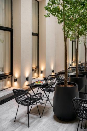 a restaurant with tables and chairs and a tree at Efe Hotel & Cowork in Buenos Aires