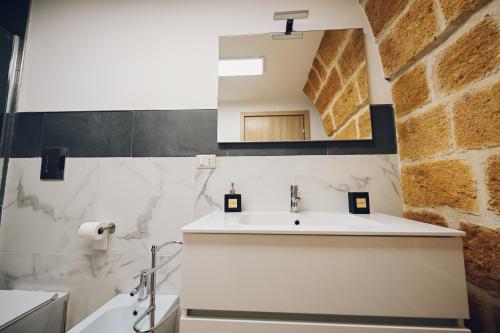 ein Bad mit einem Waschbecken und einem Spiegel in der Unterkunft La conigliera in Brindisi