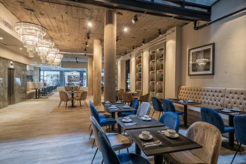 a restaurant with wooden tables and blue chairs at Efe Hotel & Cowork in Buenos Aires