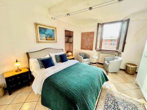 een slaapkamer met een bed, een stoel en een raam bij Terrazza Giuliana in Pescia