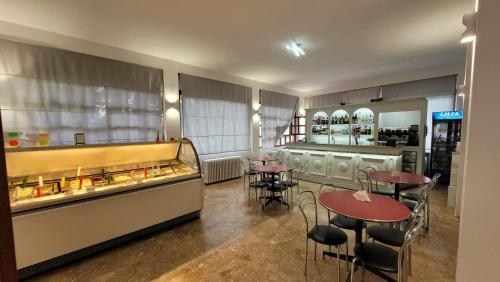 Albergo Valentini في باشينو: مطعم بطاولات وكراسي وكاونتر