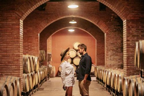 a man and a woman standing in a wine cellar at Casa Agostino - Luxury wine resort in Mendoza
