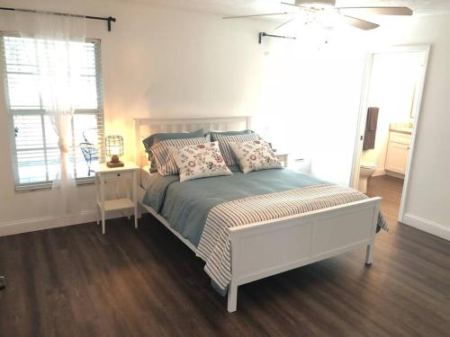 a white bedroom with a bed and a window at Beautiful Home across the street from Lake June! in Lake Placid