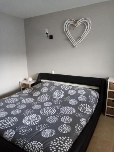 une chambre avec un lit avec un cœur sur le mur dans l'établissement Villa J et V, à Bédarrides