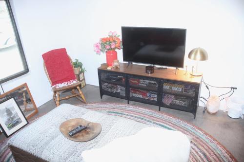 a living room with a flat screen tv and a remote at Cozy Fresh Desert Hideaway, 5 mins to Joshua Tree in Twentynine Palms