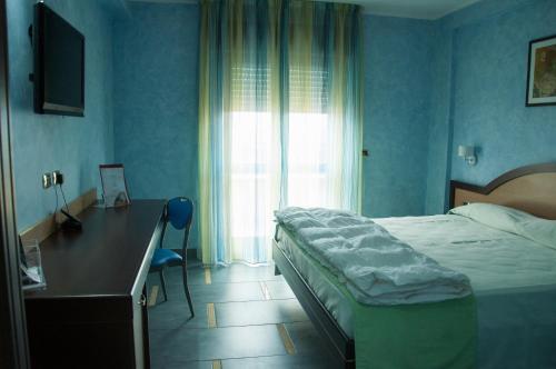 a bedroom with a bed and a desk and a window at Grand Hotel Paradiso in Catanzaro Lido