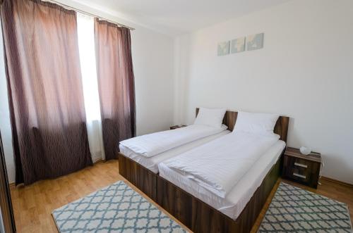 a small bedroom with two beds and a window at Hotel Apart Tel Aviv in Sebeş