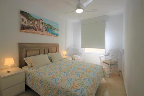 a bedroom with a bed and two chairs and a window at Apartamento CasaTuris a 60 mts de la playa y el paseo del Campello C103 in El Campello