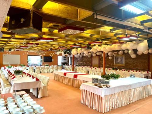 a large banquet hall with white tables and chairs at Ośrodek Wypoczynkowy MAX in Jarnołtówek