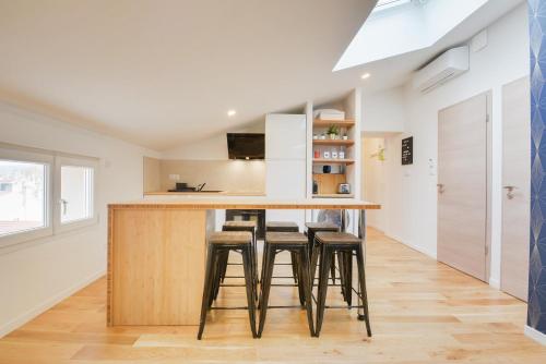 une cuisine avec un comptoir et des tabourets au bar dans l'établissement - Jacques Callot II - Veille Ville Nancy -, à Nancy