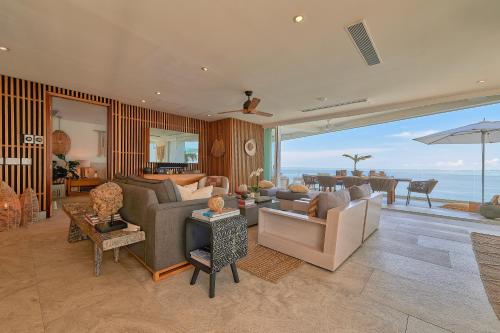 a living room with couches and a view of the ocean at Maxwell Residences at Indah in Puerto Vallarta