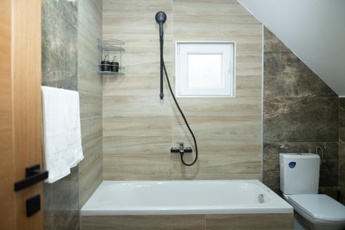 een badkamer met een toilet en een bad bij Golden House in Kolašin