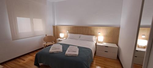 1 dormitorio con 1 cama con 2 toallas en Erdizka, céntrico apartamento turístico con la mejor vista Plaza de los Fueros, en Estella