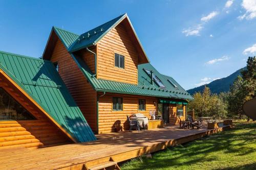 a log cabin with a green roof and a deck at Stunning 360° Views - Hiker's Paradise! in Cascade-Chipita Park
