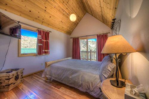 a bedroom with a bed and a lamp in a room at Stunning 360° Views - Hiker's Paradise! in Cascade-Chipita Park
