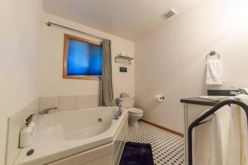 uma casa de banho com uma banheira, um WC e uma janela. em Stunning 360° Views - Hiker's Paradise! em Cascade-Chipita Park