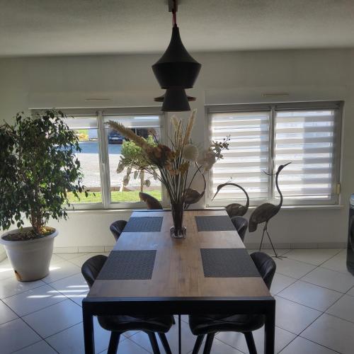 une salle à manger avec une table, des chaises et des fenêtres dans l'établissement L'Hôte du Malsaucy, à Évette