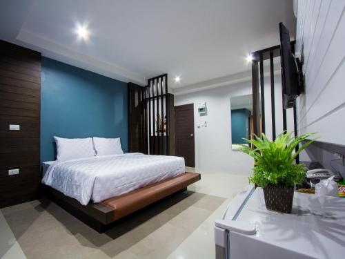 a bedroom with a bed and a blue wall at Maison de Cheer in Trang