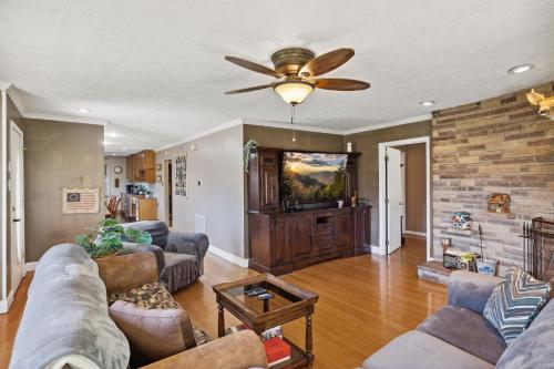 a living room with a couch and a ceiling fan at Mid-Century Vintage Brick Ranch Upstairs Guesthouse in Sevierville