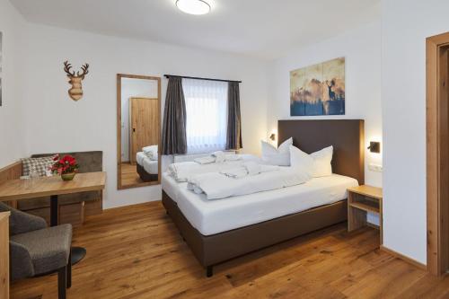 ein Schlafzimmer mit einem großen weißen Bett in einem Zimmer in der Unterkunft Gasthaus Ulrichshögl in Ainring