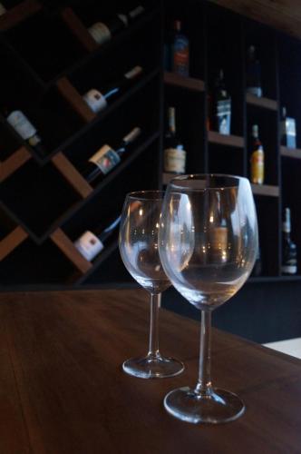 two wine glasses sitting on top of a wooden table at The Cubes Ella in Ella