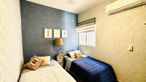 ein kleines Zimmer mit 2 Betten und einem Fenster in der Unterkunft Franks house "Shared House" in Cancún