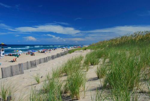 a beach with a lot of people and the ocean at Cambridge Reserve at Bermuda Bay by KEES Vacations in Kill Devil Hills