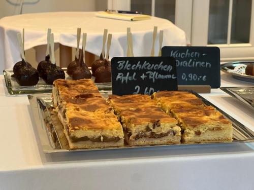 a tray of desserts on a table with chocolatecovered cookies at Landhotel Der Distelhof mit Scheunencafé in Dillstädt