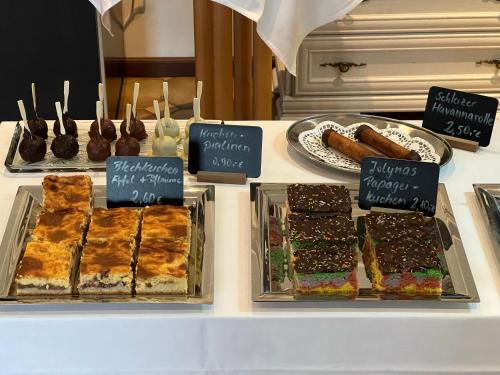 a display case with different types of cakes and desserts at Landhotel Der Distelhof mit Scheunencafé in Dillstädt