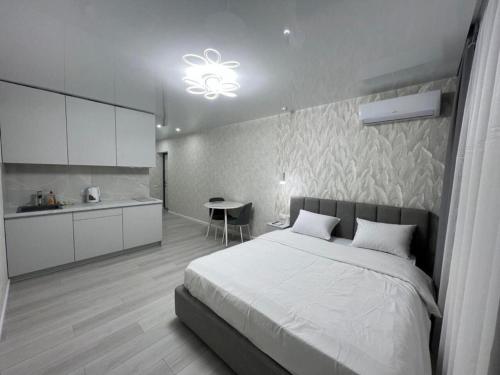 a bedroom with a large bed and a kitchen at Deluxe apartments - Viva Ukraine in Kyiv