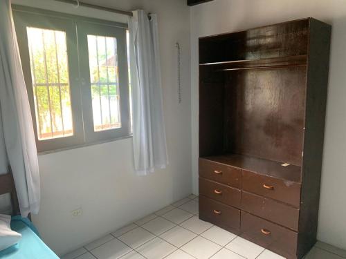 um quarto com uma cómoda e uma janela em Excelente casa na Praia do Coqueiro com 4 suítes a 100m da praia em Coqueiro