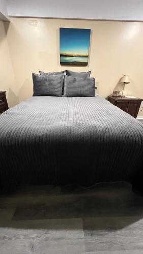 a bedroom with a large bed with a black comforter at The McNeil Mansions in Harrisburg