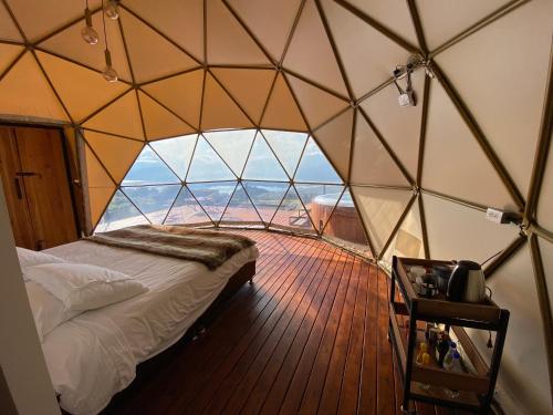 ein Schlafzimmer in einem Kuppelzelt mit einem Bett darin in der Unterkunft Casa Oro Glamping Hostel in Guatavita