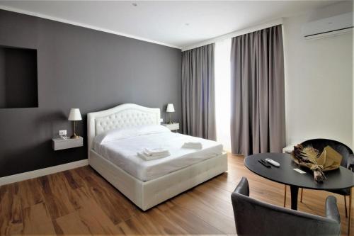 um quarto com uma cama branca, uma mesa e cadeiras em COMÓ EXCLUSIVE em Aprilia