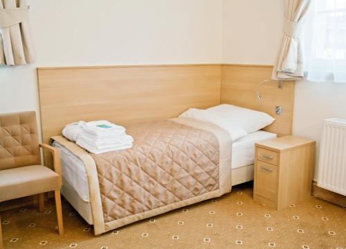 a small bedroom with a bed and a chair at Uzdrowisko Cieplice - Jelenia Góra - Długi Dom in Jelenia Góra