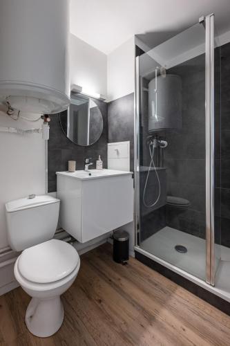 une salle de bain blanche avec toilettes et douche dans l'établissement Joli studio avec vue panoramique sur la Mer, à Houlgate