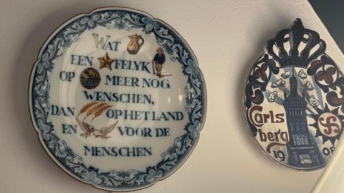 a plate on a wall with a clock on it at Ual Öömrang Wiartshüs in Norddorf