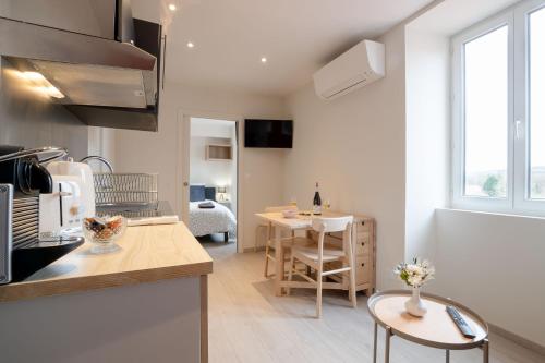 une cuisine et un salon avec une table et des chaises dans l'établissement La Source aux Cépages, à Santenay