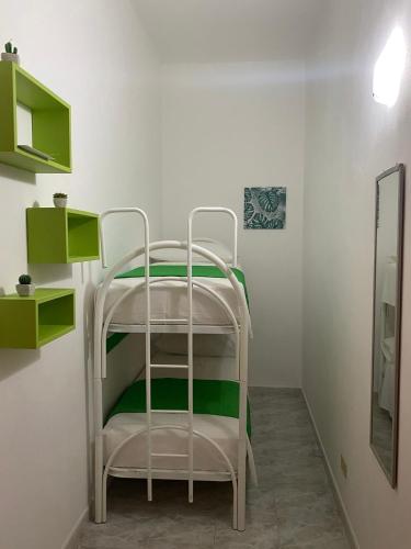 a white bunk bed in a room with green shelves at Apartment Roasi in Trapani