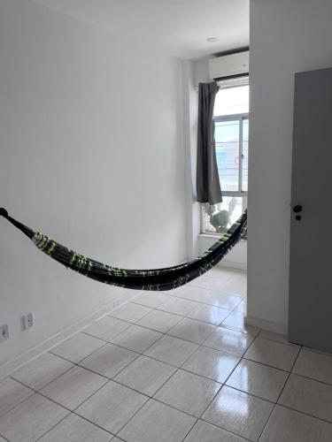 Apartamento em Amaralina في سلفادور: حبل أسود معلق من الجدار في غرفة