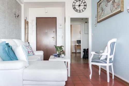 a living room with a white couch and a chair at Seafront House Free Parking AC in Alba Adriatica