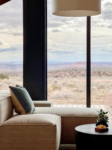 a living room with a couch and a large window at ULUM Moab in La Sal
