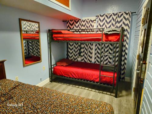 a bedroom with two bunk beds with red sheets at European Hostel in San Francisco