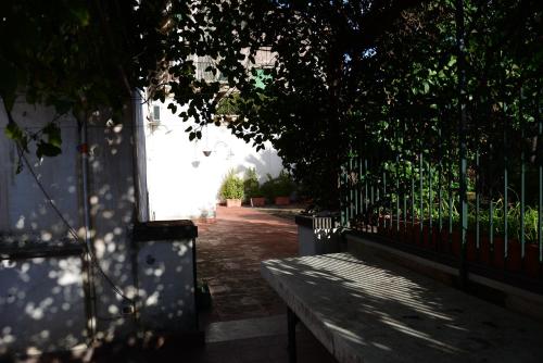 a park bench next to a fence with a tree at B&B Villa Maria in Giarre