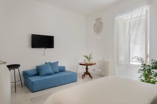 a living room with a blue couch and a tv at Palazzo Ventimiglia in Palermo