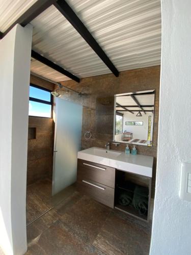a bathroom with a sink and a mirror at Casa Oro Glamping Hostel in Guatavita