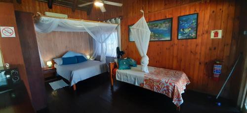 a bedroom with two beds and a canopy bed at Venha Juntos Guest Homes in Miramar