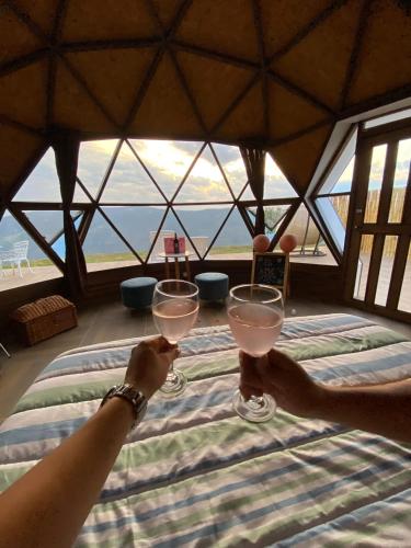 two people holding wine glasses in front of a window at Glamping Monteverde San gil in San Gil